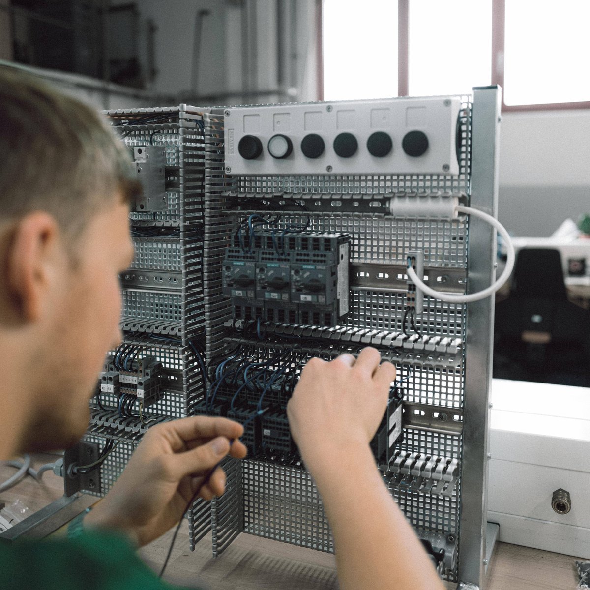Young apprentice on electrical plug-in box