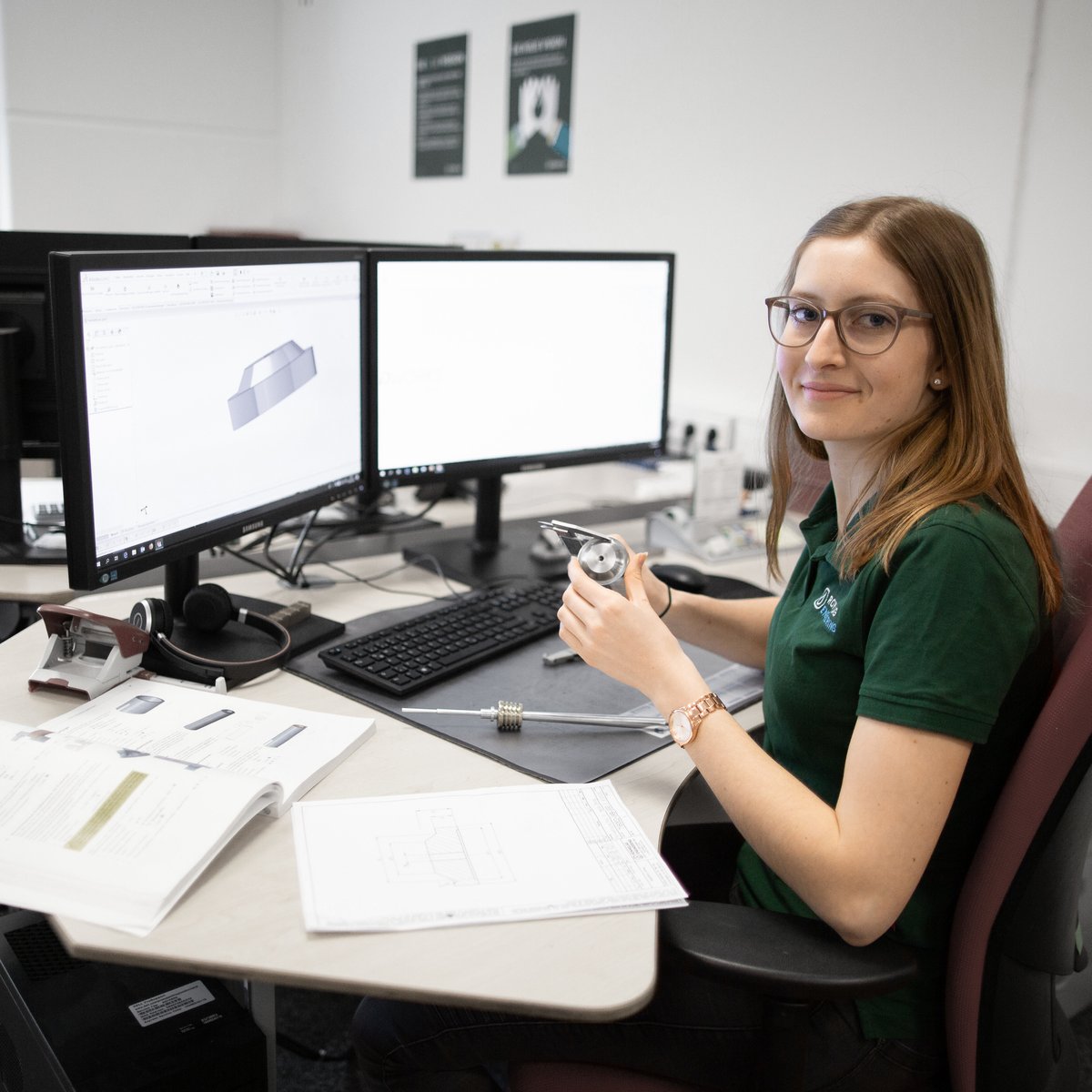Young trainee at the desk with tools and an open 3D model on the PC
