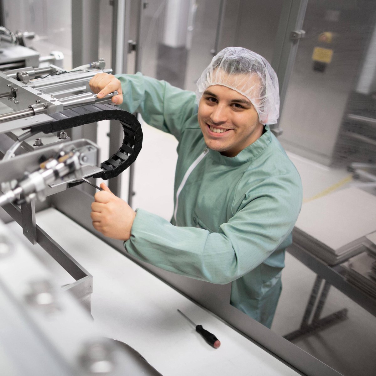 Person working on a machine installation with hairnet
