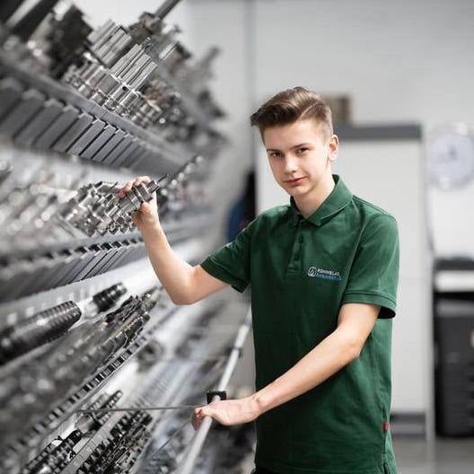 Young apprentice in front of a large tool cabinet